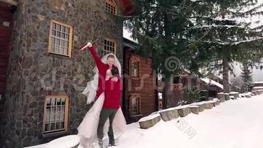 新郎旋<strong>转</strong>快乐的新娘抱着她，把她在他的手中旋<strong>转</strong>在雪<strong>天气</strong>附近的滑雪胜地村舍。 快乐